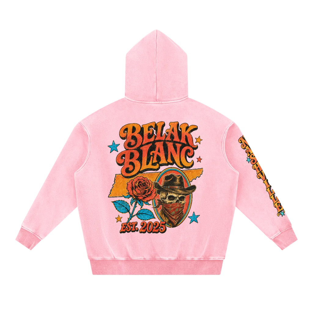 A light pink hooded sweatshirt shown from the back, featuring a large graphic print with the words 'BELAK BLANC' in orange and yellow, a rose, a skull wearing a cowboy hat, blue stars, and 'EST. 2025' near the bottom.
